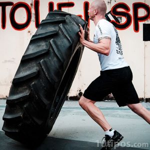 Atleta levantando neumático como ejercicio
